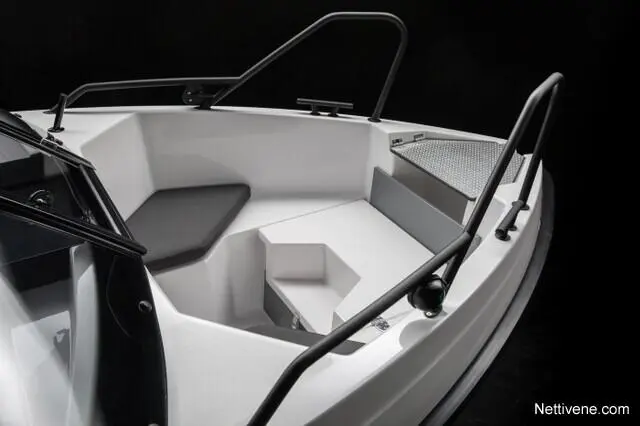 Interior of a sleek, modern boat featuring a white seating area, black accents, and a spacious layout. Nettivene.com.